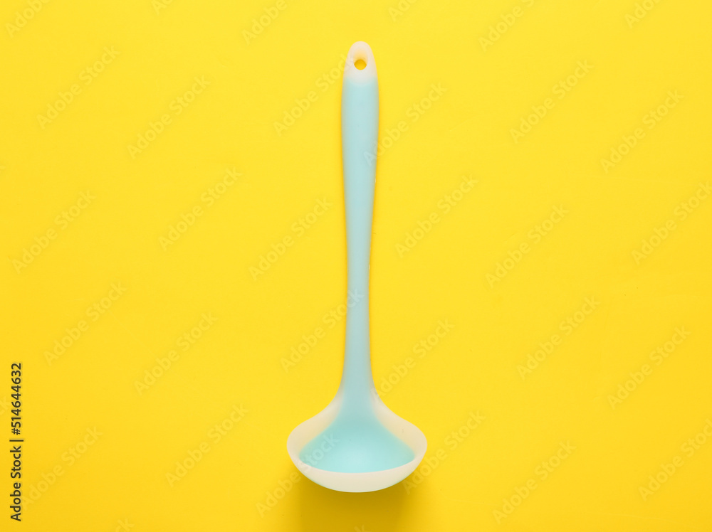 Silicone ladle on a yellow background. Top view Silicone ladle on a yellow background. Top view