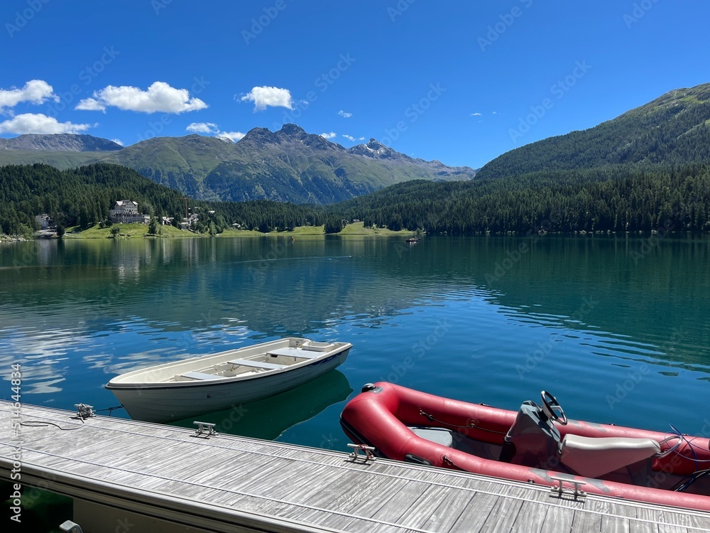 Wooden pier and boats at St. Moritzersee in Graubuenden, Grisons, Switzerland.