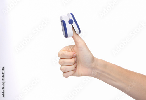 Hand finger with pulse oximeter clip isolated on white background. Measure the saturation of hemoglobin with oxygen in arterial capillary blood. photo