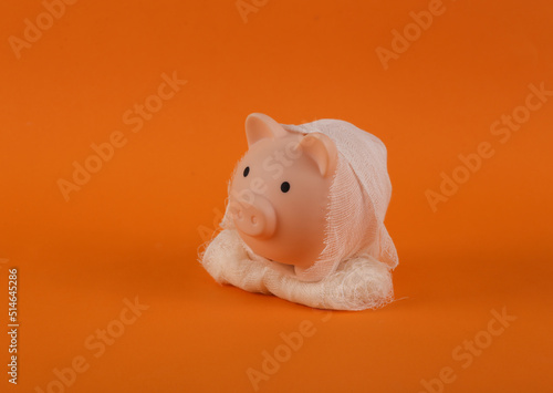Photography Mummy piggy bank wrapped in bandages on orange background