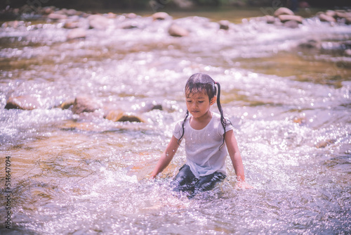 girls having fun playing in the waterfall