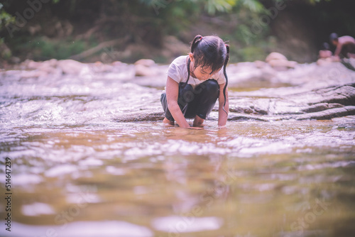 girls having fun playing in the waterfall