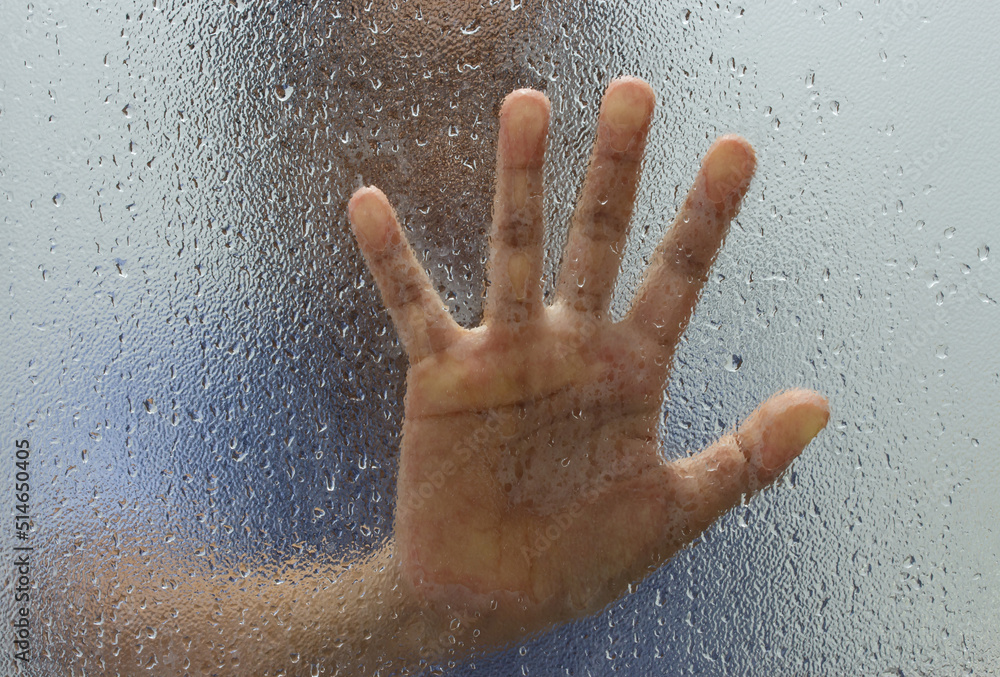 Hand of stranger on frosted glass with water drop Hand of stranger on frosted glass with water drop