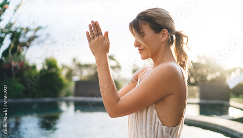Girl practice yoga and meditate near swimming pool