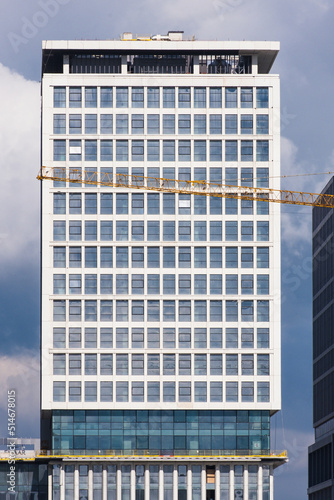 Office building with glass and metal facade. Residence building front view in cloudy weather.