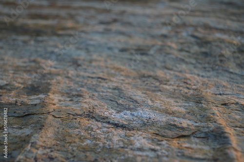 Rough texture of fine natural stone, photographed during golden hour, selective focus