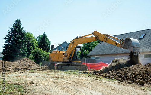 Construction Backhoe Dumping Excavated Dirt  photo