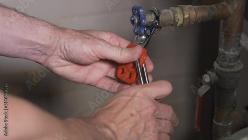 A close up view of a worker attaching a lock-out tag-out lock on a machine.  	 photo