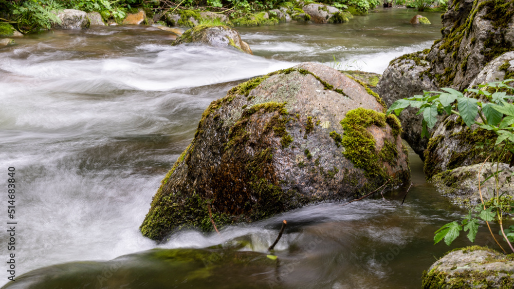Dripping river in the mountains, its rocks and lush vegetation Dripping river in the mountains, its rocks and lush vegetation