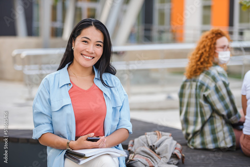 Canvas Print Portrait of a Beautiful smiling black hair Asian student girl sitting in front o