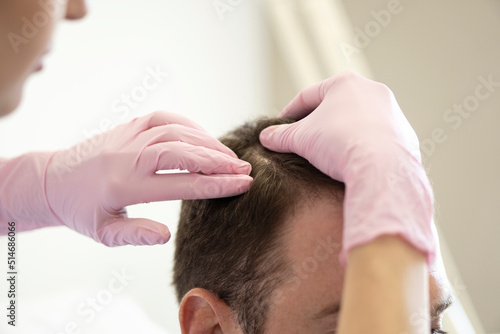 Trichologist examining scalp of patient