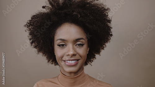 Closeup of a smiling young Latin afro woman. Joy, positive and love. Beautiful african-style hair.