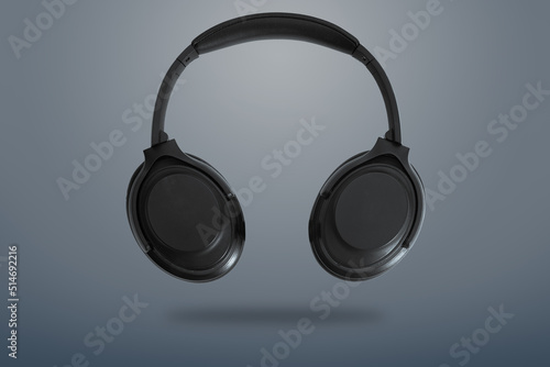 Computer headphones. Black headphones on a dark grey background. The concept of listening to music, creating audio, music. Computer work, abstraction and minimalist style.