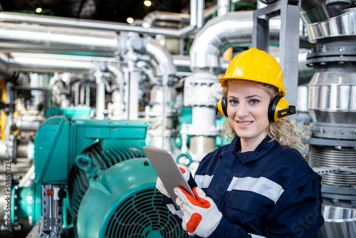 Portrait of female heating plant worker holding tablet computer and controlling gas consumption and water temperature.