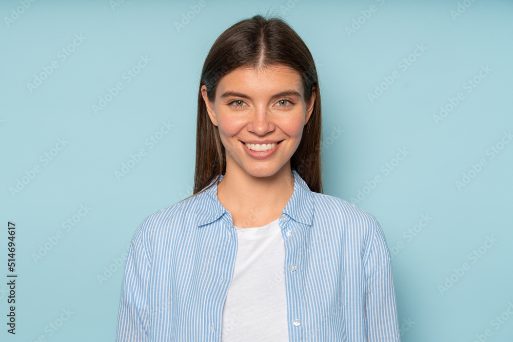 Half length portrait of lovely smiling female student posing over blue background in casual clothes Half length portrait of lovely smiling female student posing over blue background in casual clothes