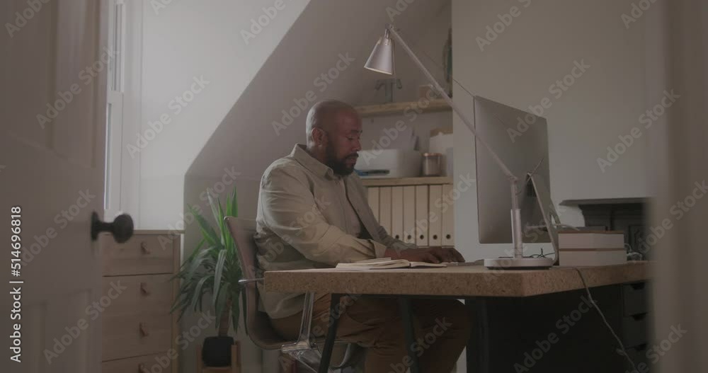 Mature Male Working from Home on Computer in Domestic Room