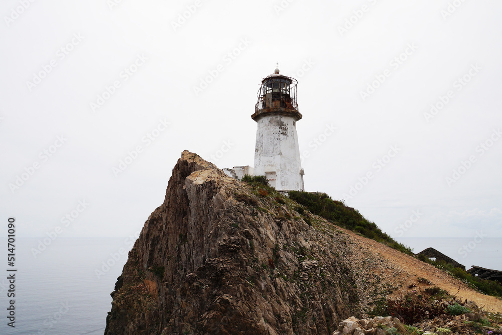 old lighthouse rising high on rocky cliff
