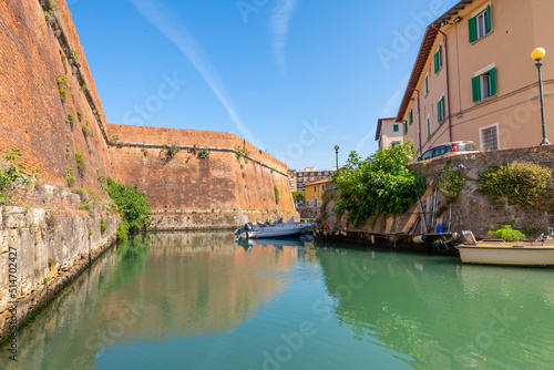 View of the brick outer walls of the Fortezza Nuova, or new fort from a canal in the New Venezia region of the port of Livorno, Italy.