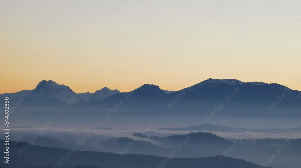 Un mare di nebbia e nuvole al tramonto riempie le valli ai piedii dei monti appennini