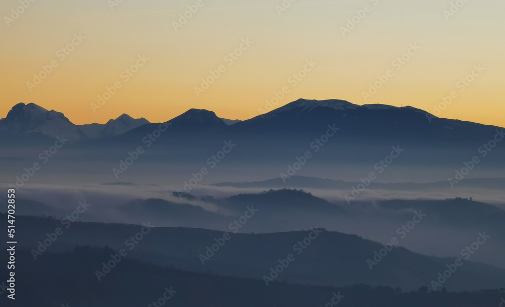 Un mare di nebbia e nuvole al tramonto riempie le valli ai piedii dei monti appennini