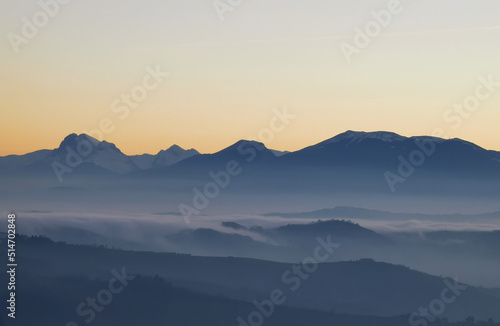 Un mare di nebbia e nuvole al tramonto riempie le valli ai piedii dei monti appennini