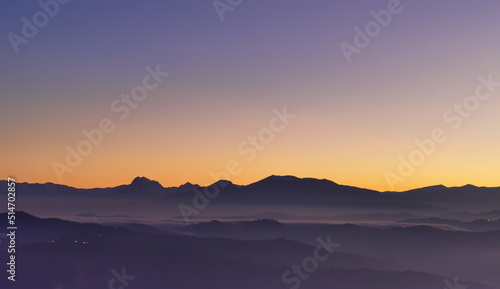 Tramonto viola e arancio sui monti le valli e le colline