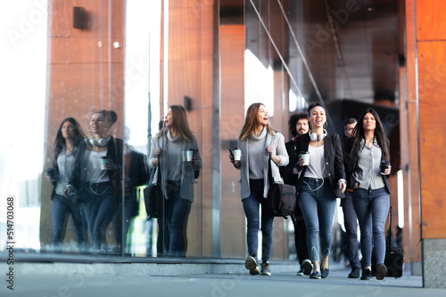 Group of people walking on a street with confidence. Businessmen and businesswomen traveling together..