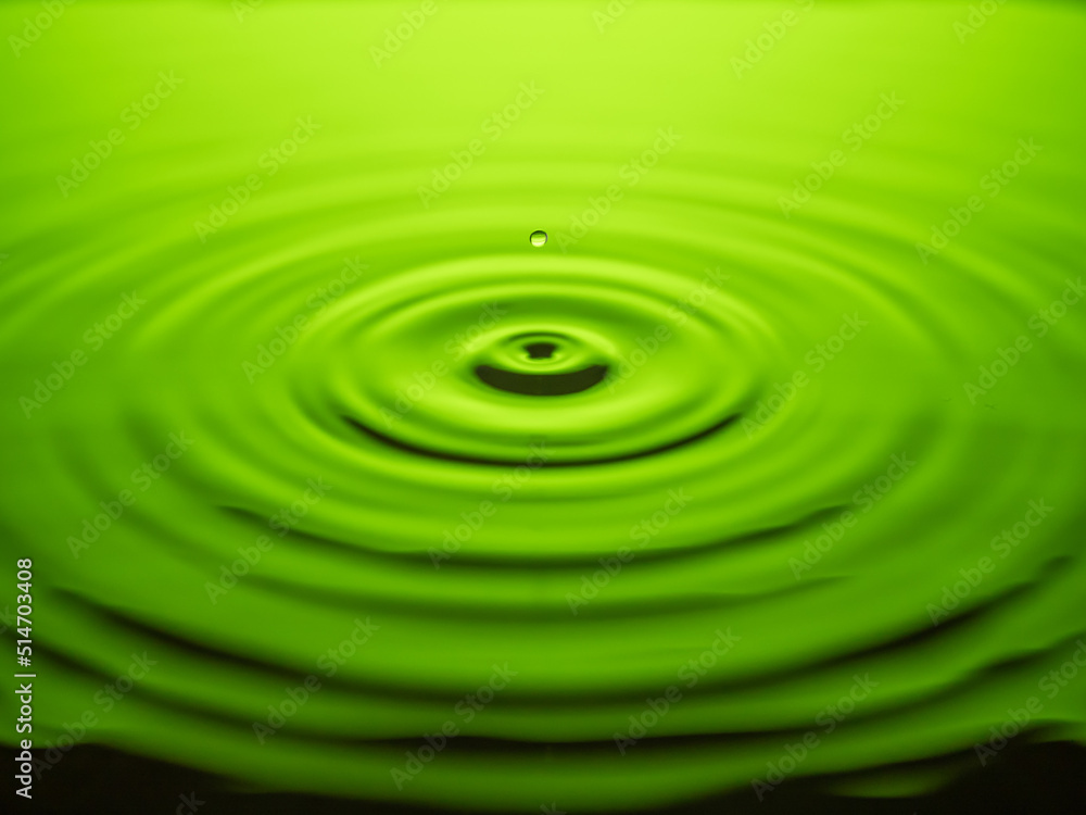Closeup of water drop falling down on green
