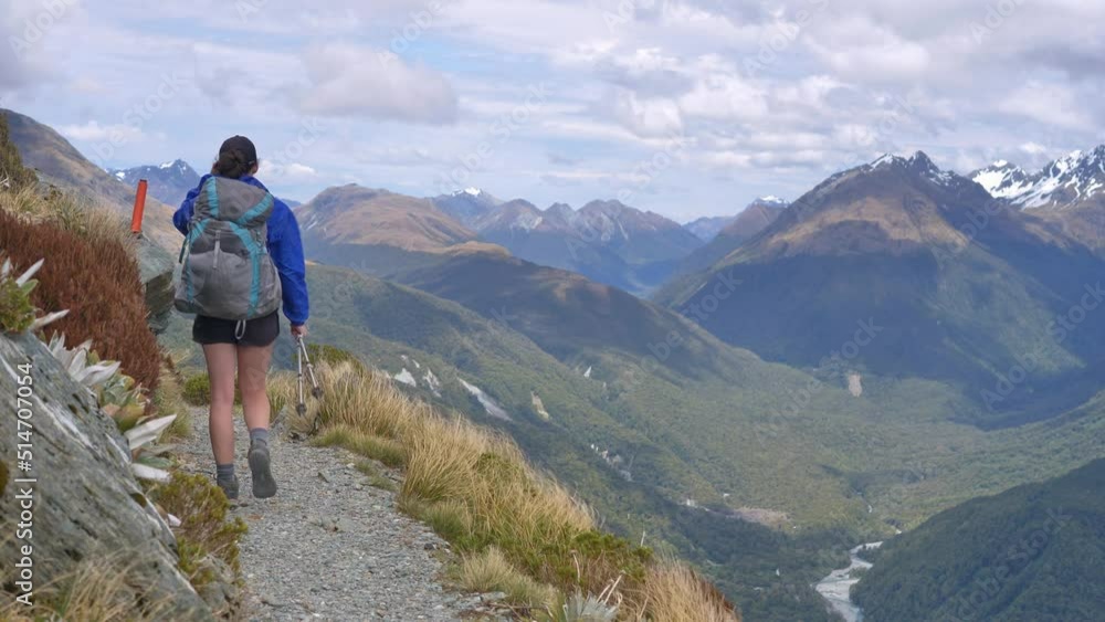 Static, hiker walks exposed windy alpine track, distant valleys, Routeburn Track New Zealand Static, hiker walks exposed windy alpine track, distant valleys, Routeburn Track New Zealand