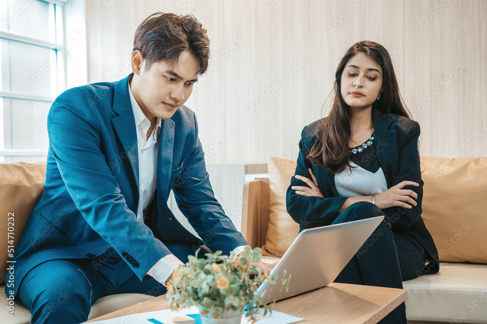Angry and unhappy india asian businesswoman arguing with businessman about work failure at office, executives having conflict over responsibility for bad work results in office with man in foreground Angry and unhappy india asian businesswoman arguing with businessman about work failure at office, executives having conflict over responsibility for bad work results in office with man in foreground