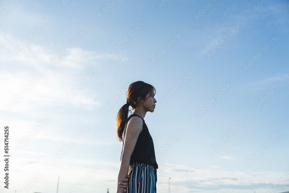 夕暮れの海を散策する女性 夕暮れの海を散策する女性