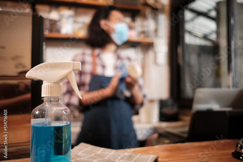 Wallpaper Mural Alcohol sanitizer for healthy protection in a cafe, Asian male barista in face mask use laptop, waiting for coffee order in COVID19 pandemic quarantine, the economic impact for small business startup. Torontodigital.ca