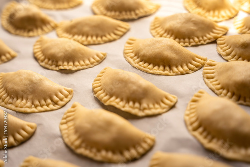 Pierogi, pirohy, filled dumplings on a baking paper, uncooked dough, Slovak dish, preparing food, cuisine photo