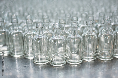 Lines of empty glass bottles for vodka drink in workshop
