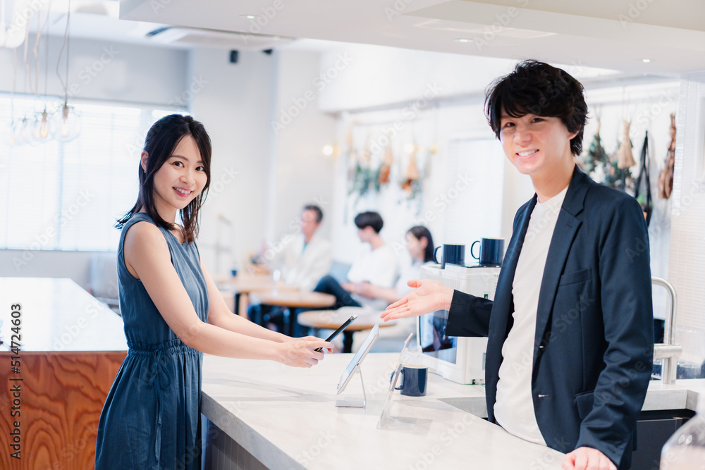スマホ決済をする若い女性 スマホ決済をする若い女性