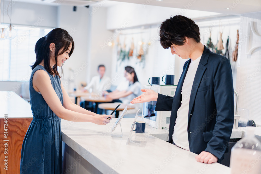 Fototapeta premium スマホ決済をする若い女性