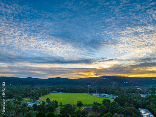Aerial sunset landscape with mountain range and sports ground