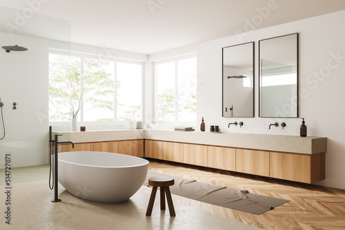 Light bathroom interior with bathtub  shower  sink and panoramic window