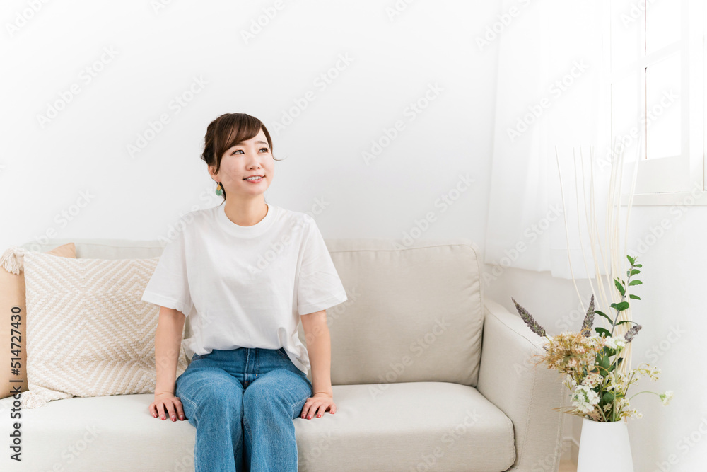 家のソファに座る笑顔の日本人女性(窓・紫外線)
家のソファに座る笑顔の日本人女性(窓・紫外線)