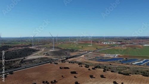 Large wind turbines with blades in field aerial view bright orange sunset blue sky wind park drone turn.  Alternative energy (ID: 514727480)