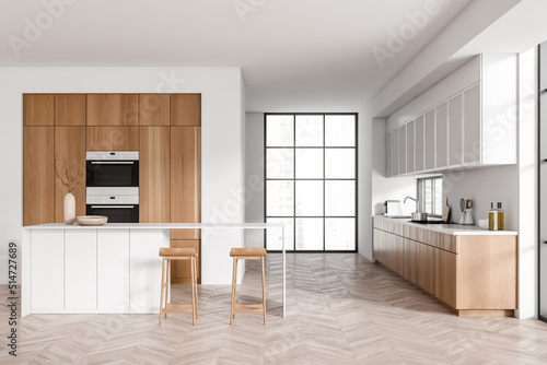 Light kitchen interior with island and seats, appliances and panoramic window