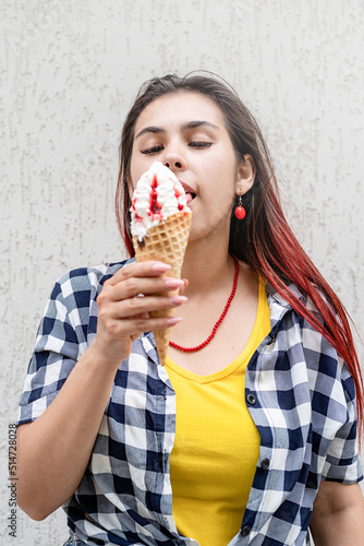 cheerful trendy woman with red hair eating ice cream at street