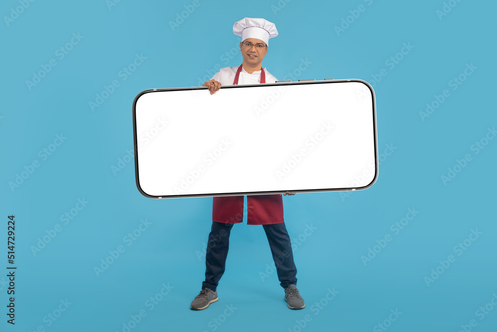 Chef phone. Big phone in hands of chef. Satisfied restaurant chef shows cellphone. Man in uniform of restaurant employee. Smartphone mockup with place for text. Space for apps in cellphone Chef phone. Big phone in hands of chef. Satisfied restaurant chef shows cellphone. Man in uniform of restaurant employee. Smartphone mockup with place for text. Space for apps in cellphone
