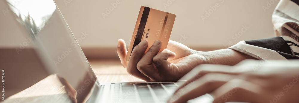 Woman's finger presses a keyboard and holds a credit card to register for payment or online transactions, Financial transactions and Internet security, Shopping online and banking online concept. Woman's finger presses a keyboard and holds a credit card to register for payment or online transactions, Financial transactions and Internet security, Shopping online and banking online concept.
