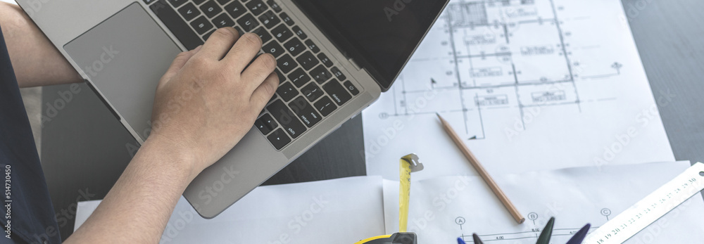 Foto de Young man with a laptop plotting a system of building ...