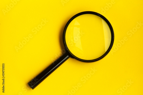 Canvas Print Blank magnifying glass on blue yellow background.