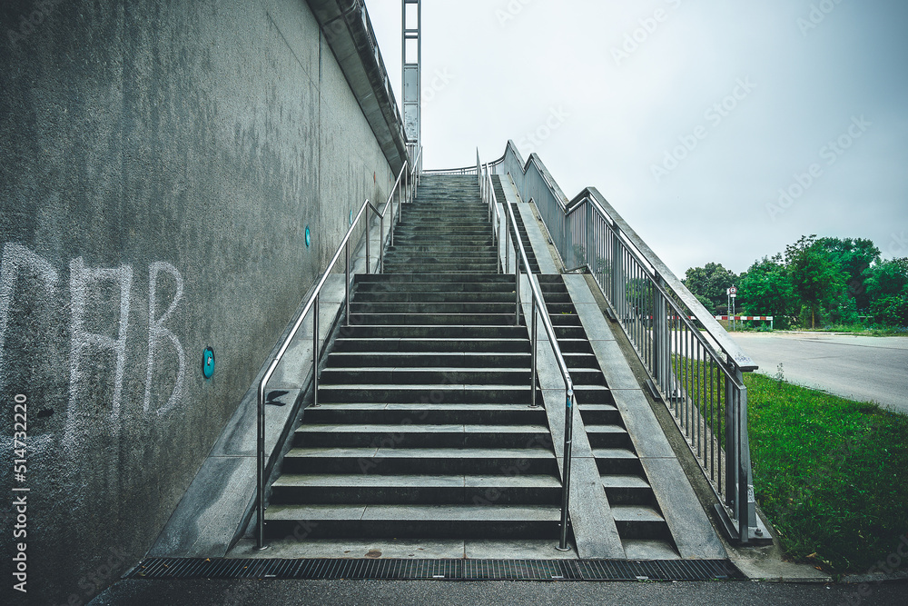 concrete staircase with handrail outdoors with gloomy sky