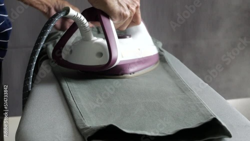 Man hand steam iron cloths 