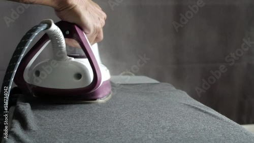 Man hand steam iron cloths 