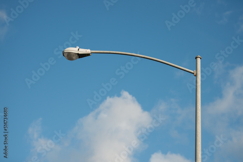 street lamp post with blue sky and white clouds photo